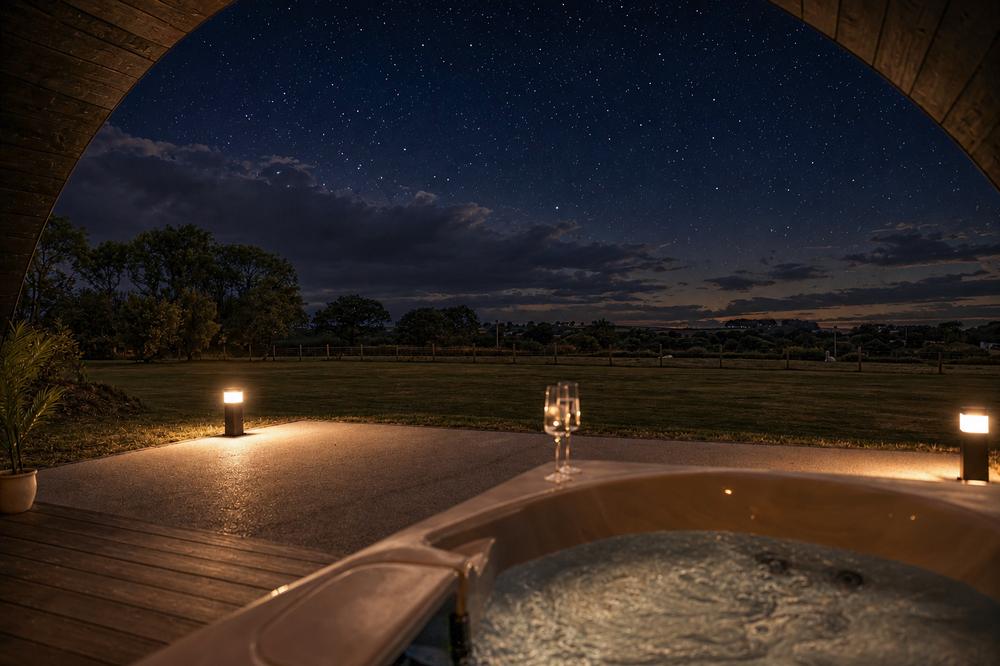 The view from the hot tub across open farmland under a starlit sky