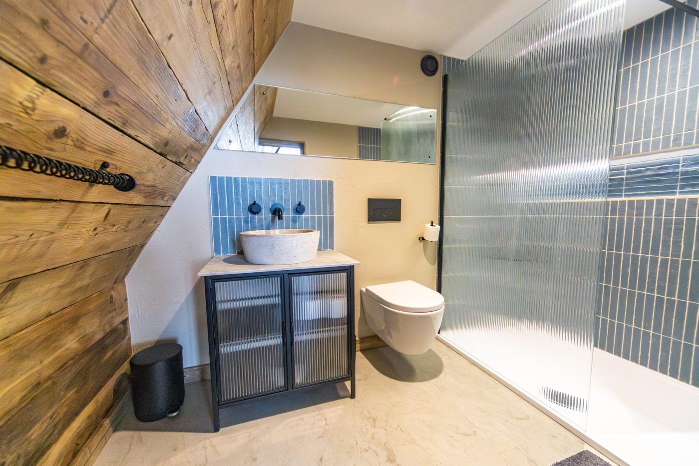 Boutique bathroom in the Tri-Pod — blue zellige tiles, stone vessel sink, walk-in shower