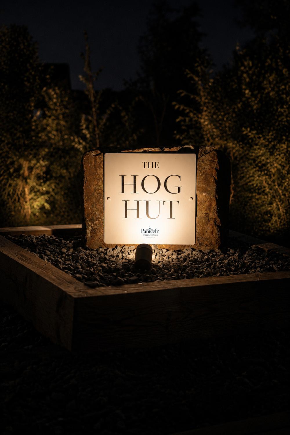 The Hog Hut's illuminated stone signage after dark