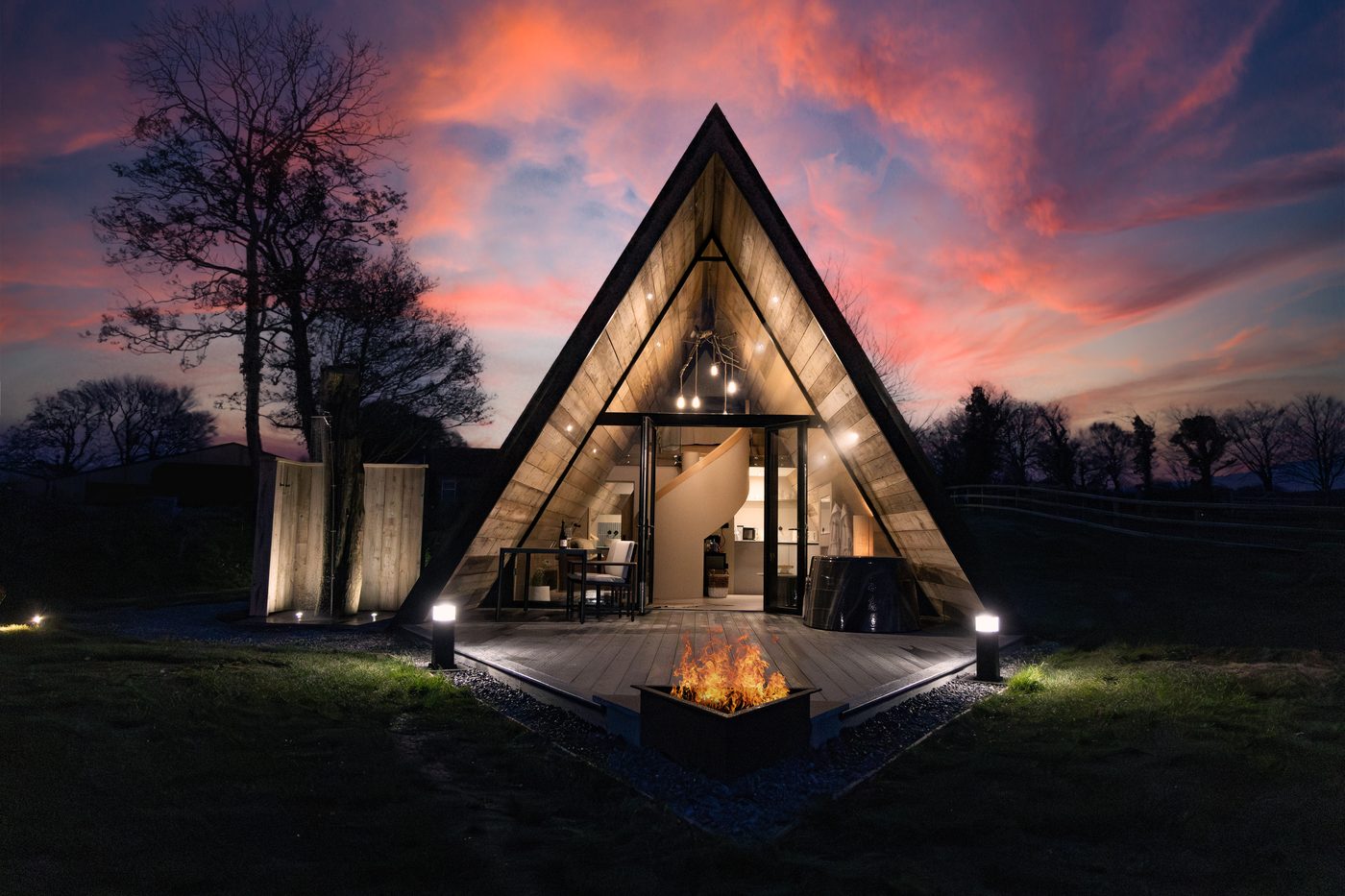The Tri-Pod A-frame at dusk with fire pit glowing, Pantcefn Ceredigion