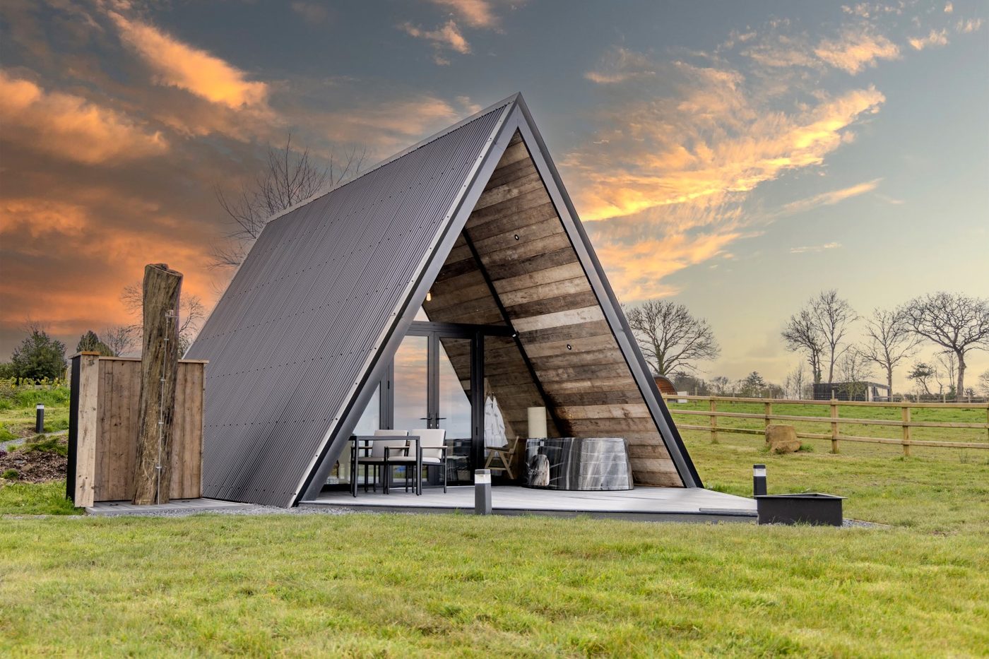 The Tri-Pod exterior at golden hour — corrugated zinc and reclaimed timber