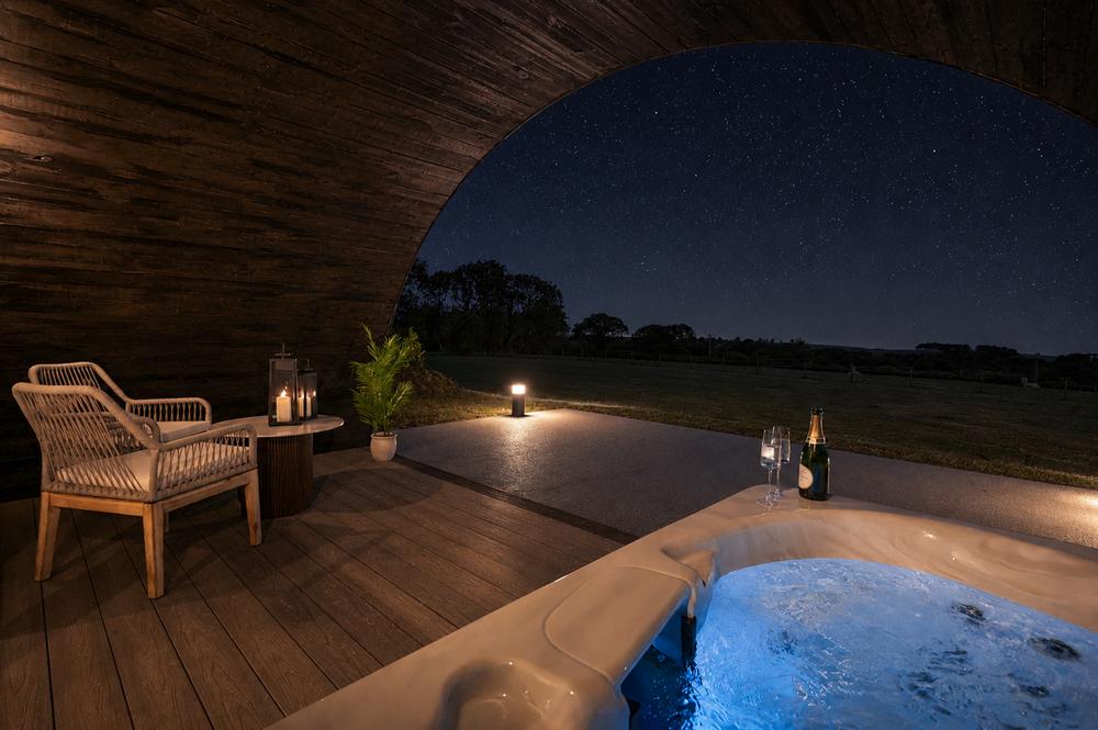 Deck chairs, lanterns and the hot tub under a starlit sky