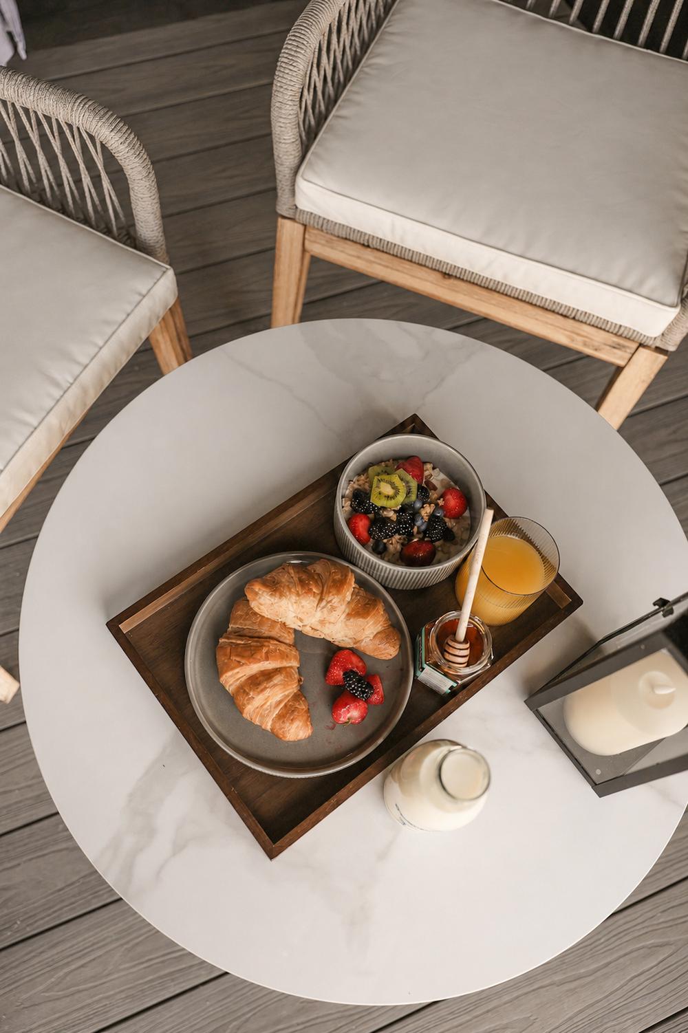 Pastries, fruit and coffee served on the deck table