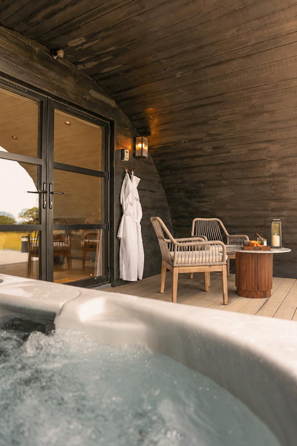 The hot tub and seating area beneath the arch at dusk