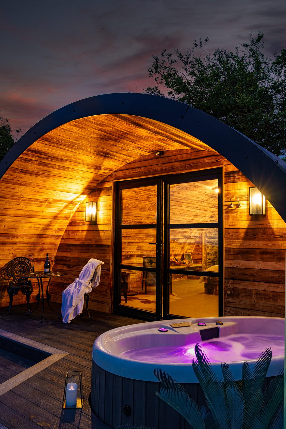 The Piglet Pod hot tub at night with purple chromotherapy lighting